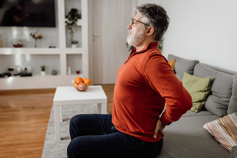 man with back pain stretching