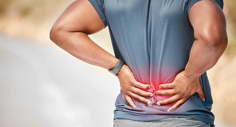 man with lower back pain after running outdoors